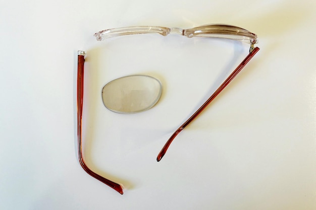 Foto direct boven opname van gebroken bril op witte achtergrond