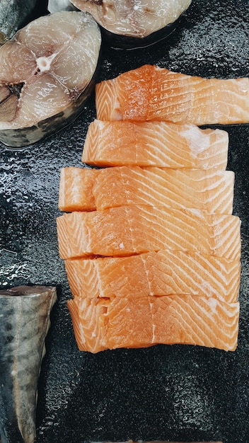 Direct boven opname van gesneden zalm op zwart marmer