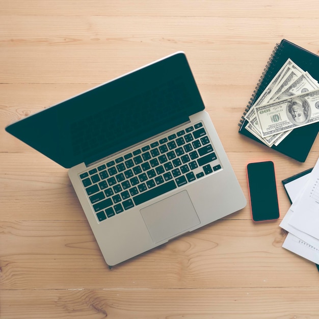 Foto direct boven opname van laptop met papiergeld op het bureau
