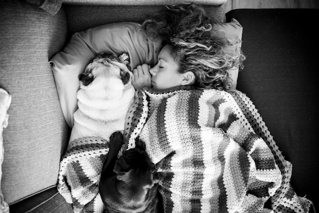 Foto direct boven opname van vrouw die met honden op bed slaapt