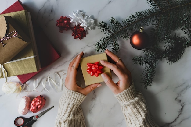 Direct boven opname van vrouw met geschenkdoos op tafel