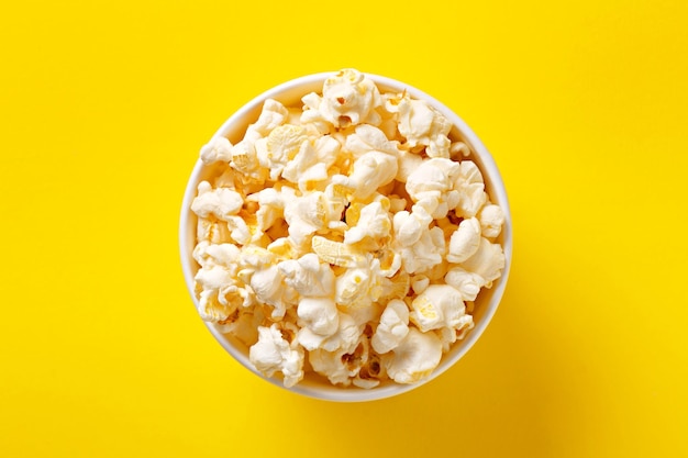 Direct boven popcorn op een gele achtergrond.