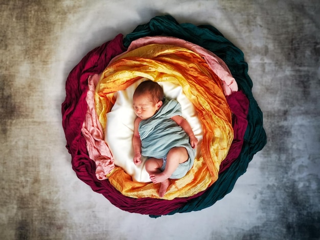 Foto direct boven schot van baby jongens slapen te midden van kleurrijke stof