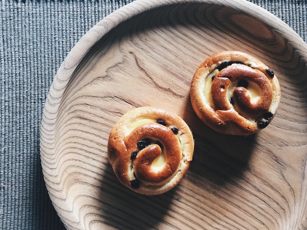 Direct boven schot van brioches in houten plaat op tafel