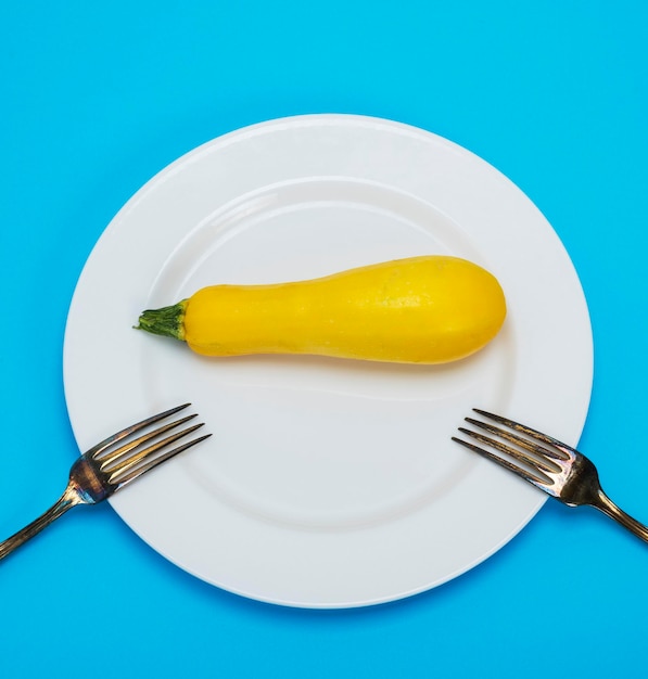 Direct boven schot van courgette in bord op blauwe achtergrond