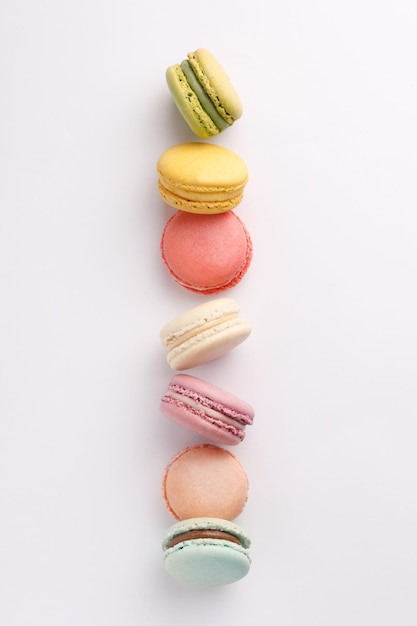 Foto direct boven schot van kleurrijke macaroons gerangschikt op witte achtergrond