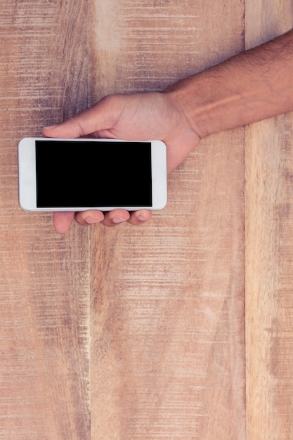 Direct boven schot van man die op telefoon boven tafel