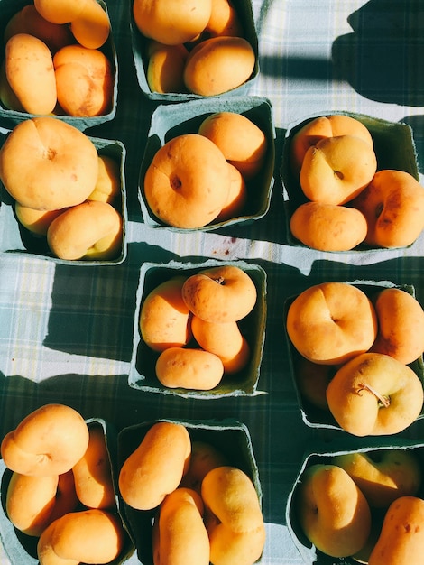 Direct boven schot van perziken in doos op tafel voor verkoop in de markt