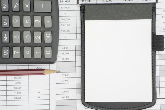 Foto direct boven schot van rekenmachine met potlood en dagboek op financiële documenten