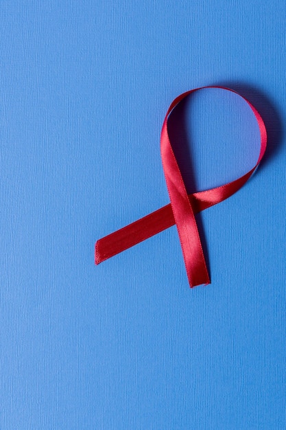 Direct boven schot van rood aids bewustzijn lint op blauwe achtergrond