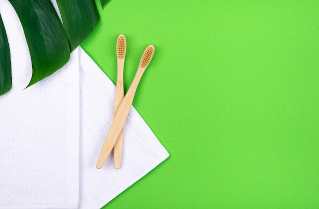 Foto direct boven schot van tandenborstels en blad over wit papier tegen groene achtergrond