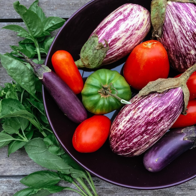 Direct boven shot van tomaten met aubergines en chili pepers in de kom