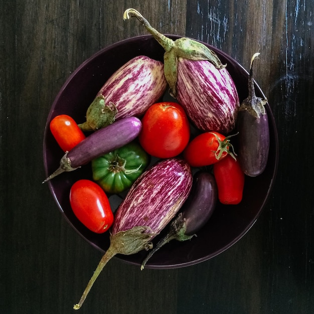 Direct boven shot van tomaten met aubergines en chili pepers in de kom
