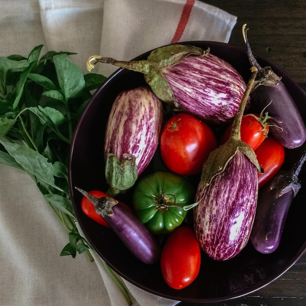 Direct boven shot van tomaten met aubergines en chili pepers in de kom