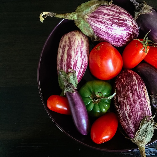 Direct boven shot van tomaten met aubergines en chili pepers in de kom