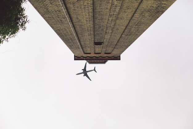 Direct hieronder schot van een vliegtuig over een gebouw tegen een heldere lucht