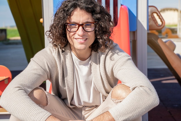 Photo direct look of a young man sitting in a park