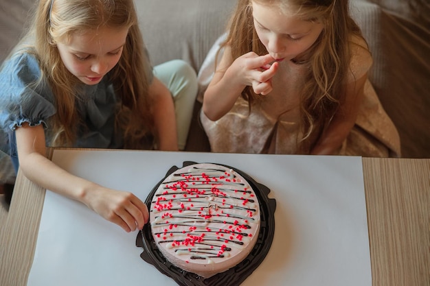 directe kinderen meisjes caps zonder aarzeling eten verjaardag mooie taart met hun handen thuis