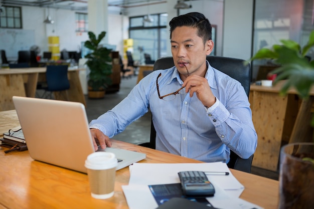 Directeur die laptop met behulp van bij bureau