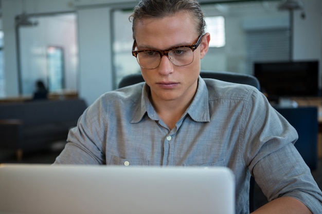 Foto directeur die laptop met behulp van bij bureau