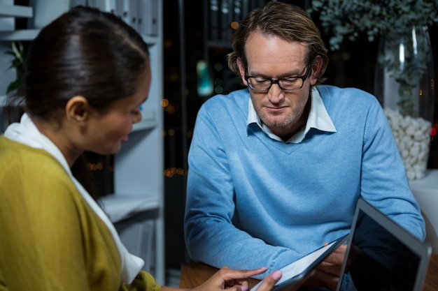 Foto directeuren die over digitale tablet bespreken