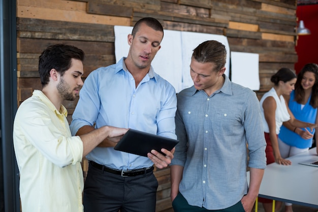 Directeuren die over digitale tablet bespreken