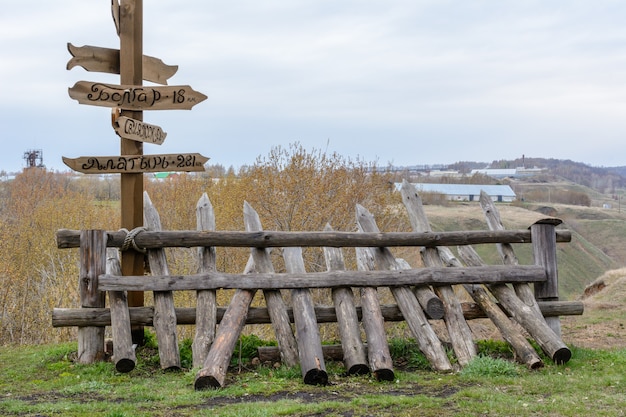 Direction arrows to the different popular towns with the distance to each city given in kilometers. Wooden signpost to Moscow, Kazan, Vladivostok, Bolgar, Alatyr. The Volga River. Tetyushi, Russia.