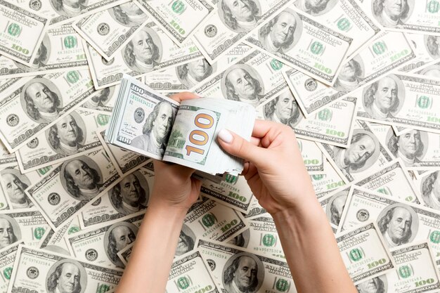 Фото Прямо над снимком с руками, держащими бумажную валюту.
