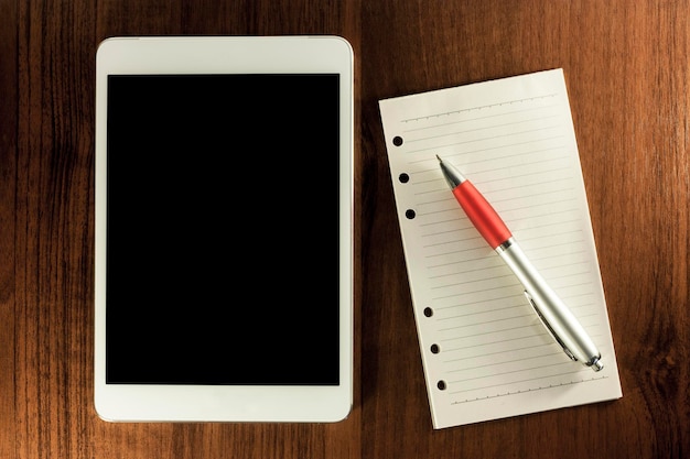 Фото Прямо над снимком цифрового планшета с дневником и ручкой на деревянном столе