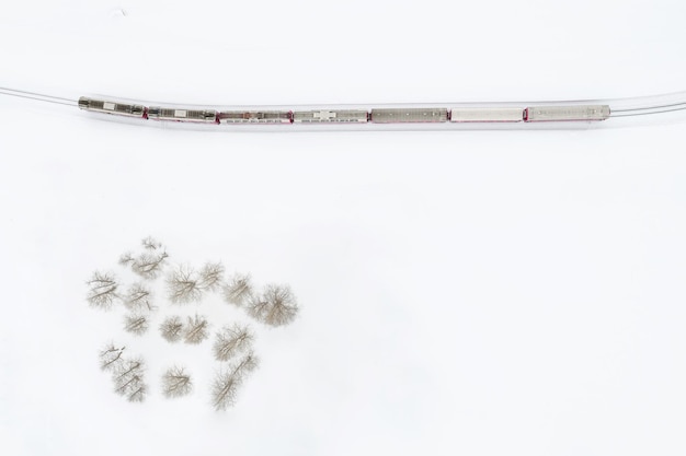 写真 雪に覆われたフィールドで動く列車のショットを直接上に