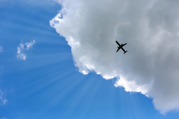 写真 雲の空に向かって飛ぶ飛行機のショットを直接下に