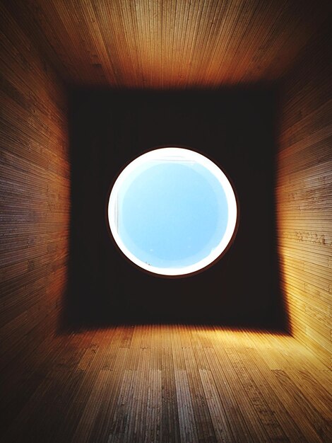 写真 明るい空を背景に円形のガラスの窓の直接下のショット
