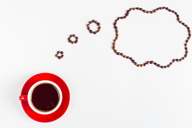 Photo directly above coffee cup with thought bubble over white background