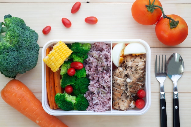 Directly above of healthy lunch box with vegetables, rice, boiled egg and chicken breast