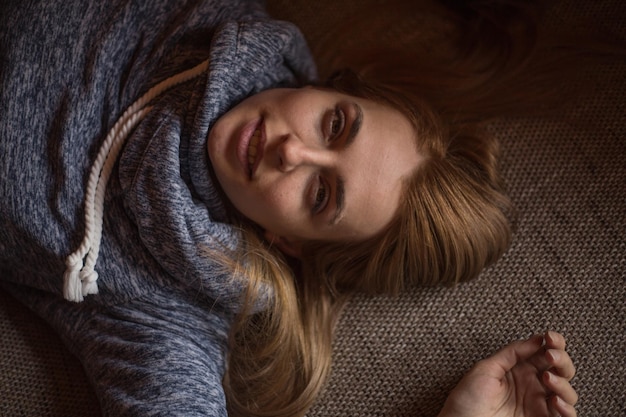 Photo directly above portrait of woman lying on carpet