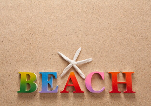 Foto directamente sopra la foto del testo sulla spiaggia con conchiglie sulla sabbia della spiaggia
