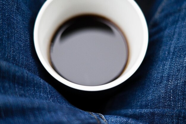 Photo directly above shot of black coffee between person lap