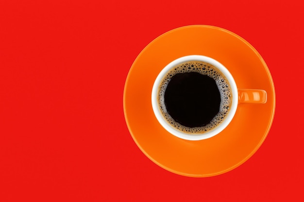 赤い背景の黒いコーヒーを直接上に撮影