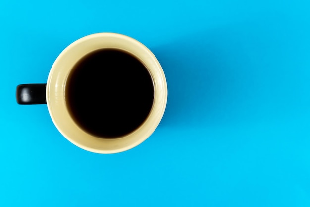 Directly above shot of black coffee on table against blue background