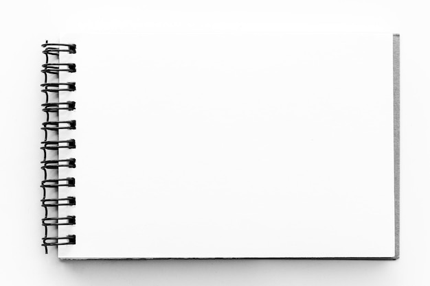 Photo directly above shot of blank spiral notebook over white background