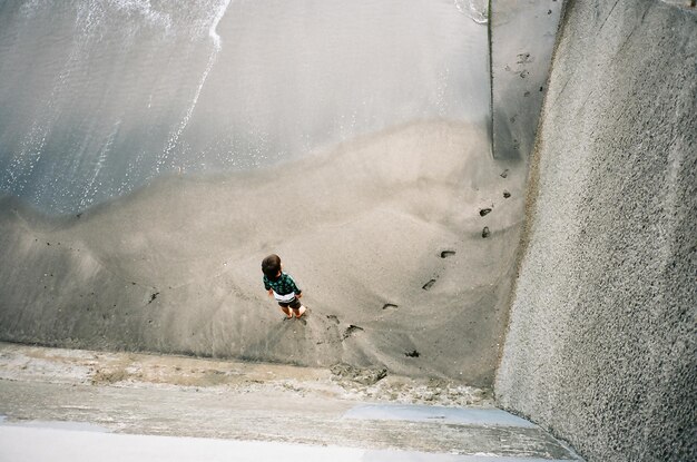 directly above shot of boy standing at beach