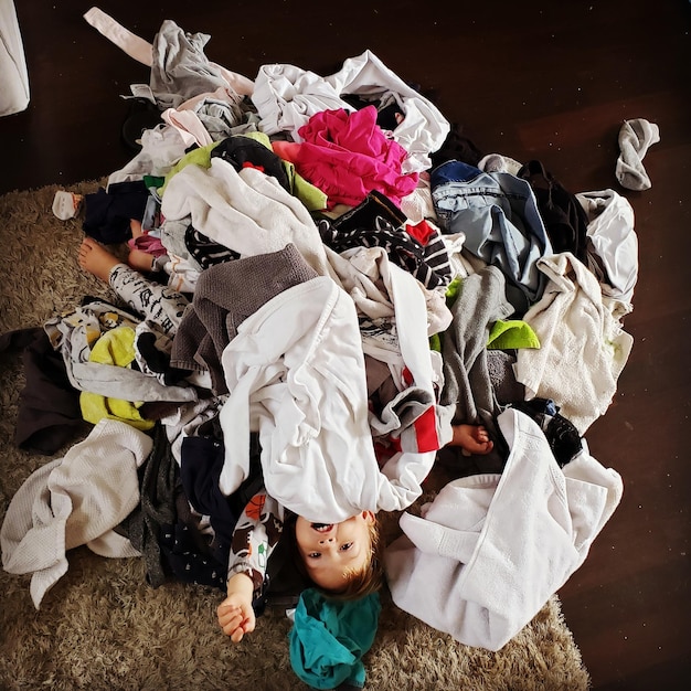 Photo directly above shot of boy with clothes on floor