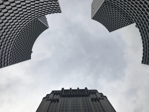 市内の雲の空に照らされた建物の直接下のショット
