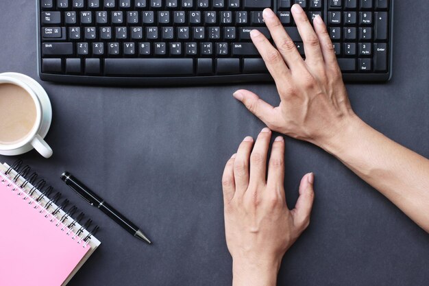 Directly above shot of business person using computer keyboard at desk in office