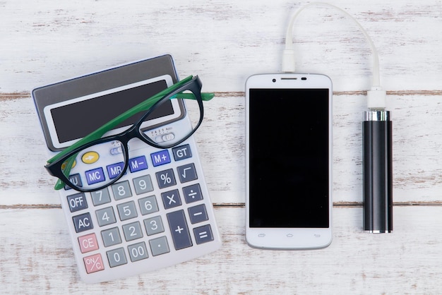 Photo directly above shot of calculator with eyeglasses and smart phone on table