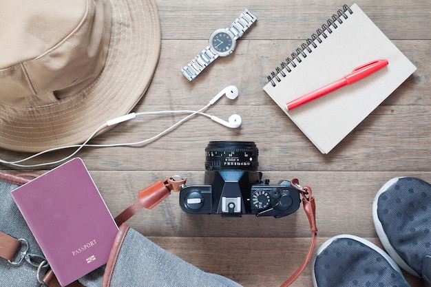 Photo directly above shot of camera surrounded with personal accessories on wooden table