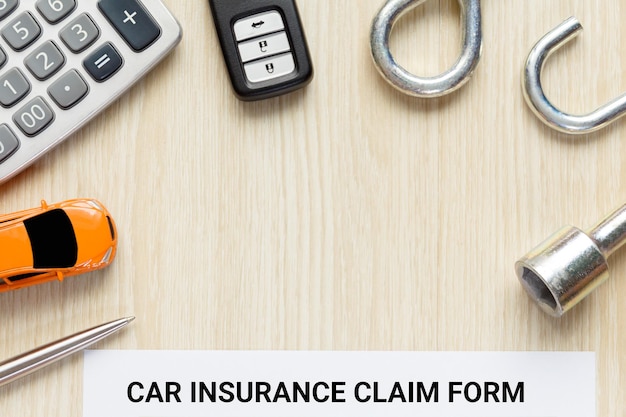 Photo directly above shot of car insurance claim form with toy and key on table