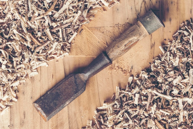 Photo directly above shot of chisel and wood shavings on table