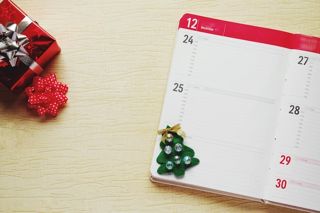 Photo directly above shot of christmas present and decorations with calendar on wooden table