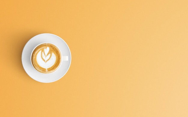 オレンジ色の背景のコーヒーカップの直接上のショット
